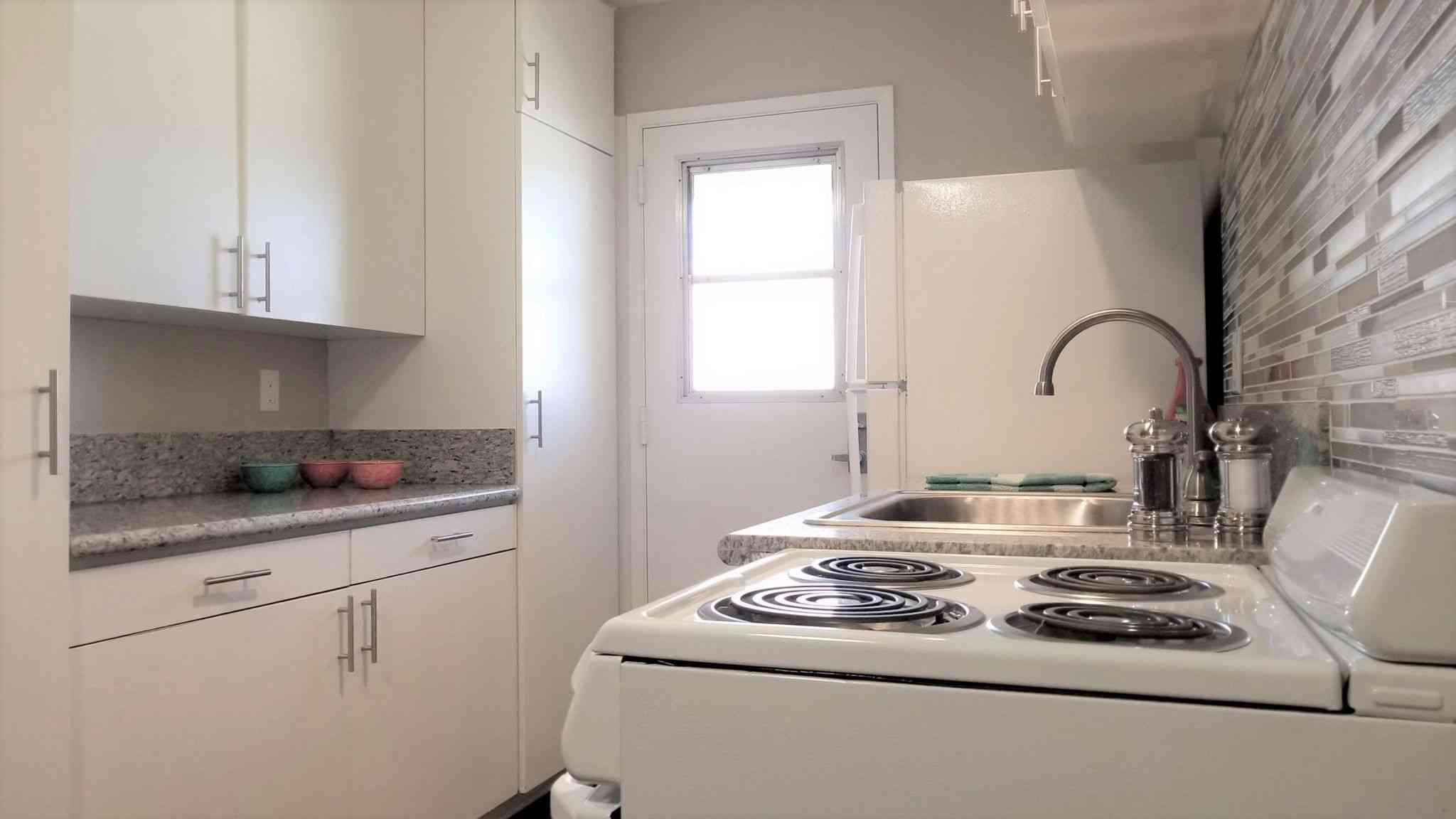 kitchen area with white appliances and cabinetry
